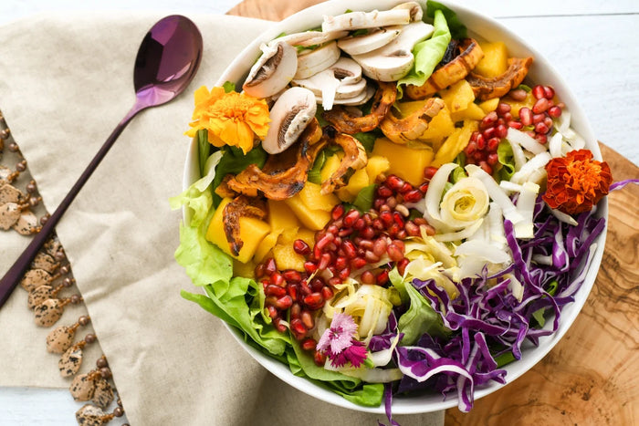 salad with fruit toppings in a white bowl on a wooden table