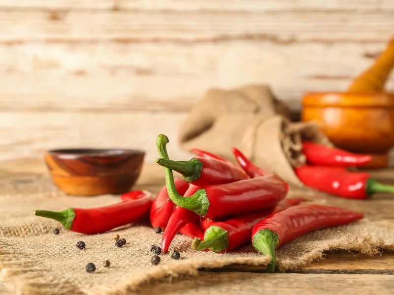 Red chili peppers on a wooden surface with a rustic background